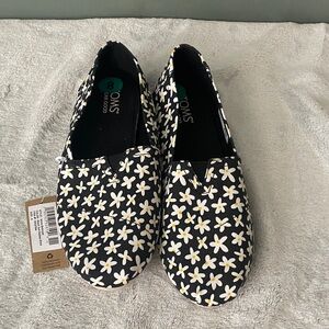 TOMS Black Canvas Slip-Ons with White and Yellow Daisy Print